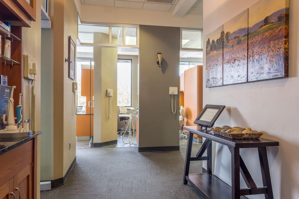 The clinical hallway leading to the treatment rooms, with a landscape triptych on the wall